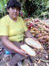 Farmer in Ucayali River region of Peru harvesting cacao and showing opened pod